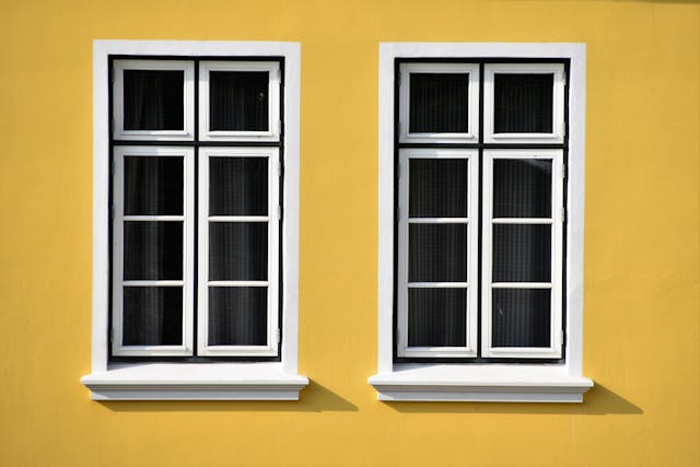 To hvide vinduer i ældre gul bygning